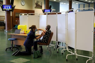 A woman receives the first of two injections of the Pfizer vaccine in Surrey, England. Reuters
