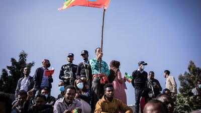 A man holds the Ethiopian national flag as new military recruits who are joining the Ethiopian National Defence Force attend the send-off ceremony in Addis Ababa, Ethiopia, on November 24, 2021. AFP
