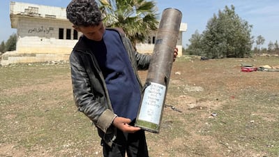 A boy holds an empty shell reportedly left behind by Israeli troops in Horsh Sad Tassil, in Syria's southern province of Deraa, on April 3. AFP