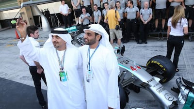 Two Emirati F1 fans take a selfie in front of Hamilton's car. Ali Haider / EPA
