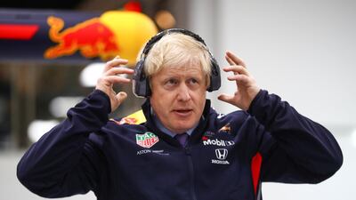 Britain's Prime Minister Boris Johnson adjusts his protective headphones during a visit at Red Bull Racing in Milton Keynes, Britain December 4, 2019 Reuters