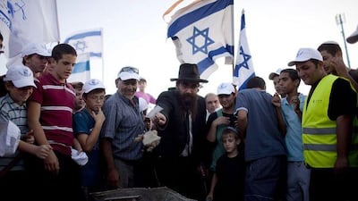 Israeli settlers lay a foundation stone to a new neighborhood near the Jewish settlement of Maale Adumim, West Bank.