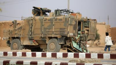 A Turkish soldier stands near his armoured vehicle on a highway near the northern Syrian town of Ain Issa in Idlib. AFP
