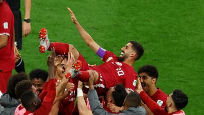Qatar players lift Hassan Al Haydos in the air to celebrate his brilliant goal against China. Reuters