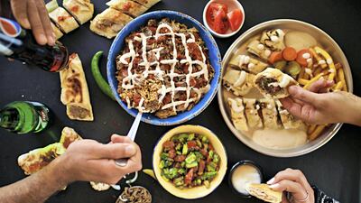 Customers tuck in to sandwiches and Shawerma Zarb's speciality dish, the Abu Arab Meal, meat and rice topped with a tomato stew. Courtesy Shadi Edwan