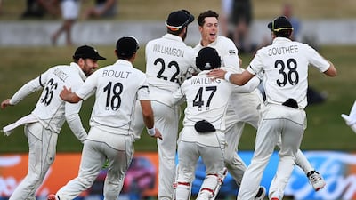 New Zealand bowler Mitchell Santner is mobbed by teammates after taking a catch to dismiss Pakistan's Naseem Shah and clinch his team's victory. AP