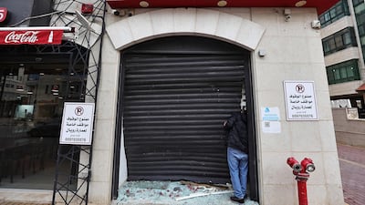 A man inspects the damage to a money exchange shop, after a raid by the Israeli army in Ramallah, in the occupied West Bank. AFP