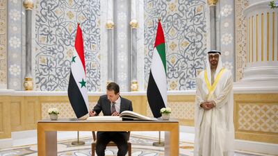 Sheikh Mohamed stands as Mr Al Assad signs a guest book. Presidential Court