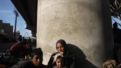Honduran mother Lorena sits on the street with two of her four children, Yasir (L) and Maria, who all trave'led together for more than one month in the 'migrant caravan', in Tijuana, Mexico. Getty