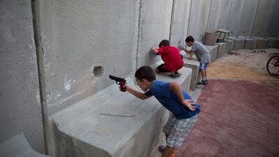 Israeli children with toy guns pretend to play war games around a kindergarten near the border with Gaza Strip. Photo: Menahem Kahana / AFP
