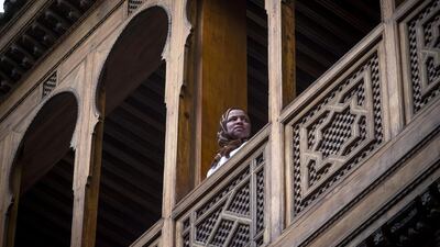 A woman stands in the balcony of a traditional building in the 9th century walled medina in the ancient Moroccan city of Fez on April 11, 2019. AFP