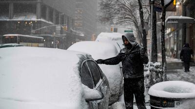 A man cleans snow from his car in New York. Jewel Samad /AFP Photo