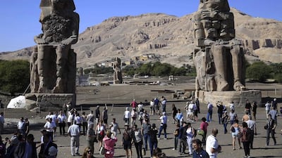 Tourists behold the Colossi of Memnon, two massive stone statues of Pharaoh Amenhotep III at Luxor. Hassan Ammar / AP Photo