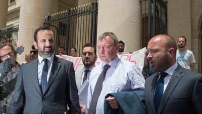Claus-Peter Reisch, the German captain of Lifeline, a private ship that rescues migrants, is flanked by his lawyers as he leaves after an arraignment hearing in Valletta, Malta. AP