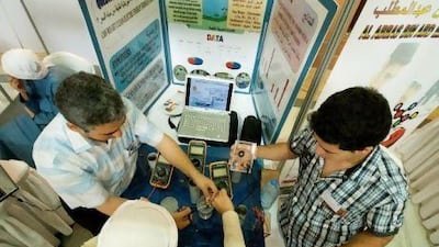 Haitham Rashid, bottom, and Ahmed Ali Ali, far right, power a small motor by dipping metals into salt water.