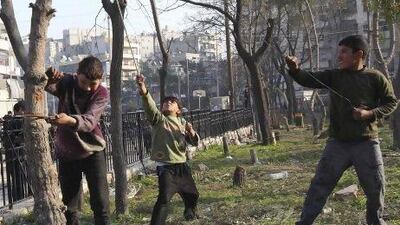 Boys cut tree branches to be used for heating at a public park in Aleppo. Shortages of electricity, water and other necessities are fuelling discontent among Syrians.