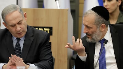 Israeli Prime Minister Benjamin Netanyahu listens to Aryeh Deri during a meeting with his nationalist allies and Likud party members at the Knesset in March 2020. AP