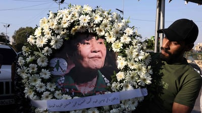 A man holds a wreath bearing an image of Japanese militant Kozo Okamoto, also known as “Ahmed al-Yabani” (Ahmed the Japanese) as members and supporters of the Popular Front for the Liberation of Palestine (PFLP), joined by Lebanese and Palestinian participants, attend his funeral procession in Beirut on July 24, 2026. The procession set off from Al-Khashoggi Mosque before burial at the Martyrs’ Cemetery of the Palestinian Revolution. Okamoto, was part of a three-man commando from the Japanese Red Army that killed 26 people, eight Israelis, a Canadian, and 17 Christian pilgrims from Puerto Rico on May 30, 1972 at Lod airport -- now known as Ben Gurion -- near Tel Aviv in an attack planned by the PFLP. Okamoto died on July 23, 2026 aged 78, the group said. (Photo by Anwar AMRO / AFP)