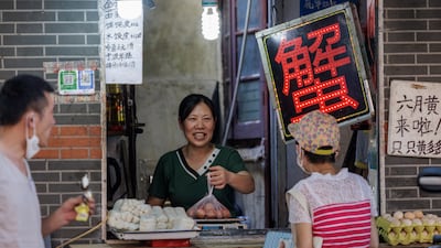 A shopkeeper hands over eggs to a customer, in Shanghai. Consumer demand in China remains depressed by the nation’s strict Covid control polices and sporadic outbreaks. EPA