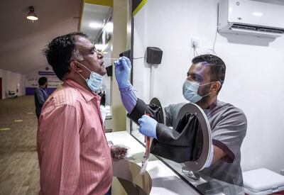 An Abu Dhabi resident receives a Covid-19 test. Mass testing is a key factor in the UAE curbing the pandemic. Victor Besa / The National
