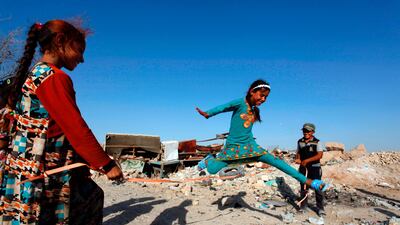 Iraqi children play in a junkyard in an improvished area in Najaf on June 27, 2017, on the second day of Eid al-Fitr holiday that marks the end of the holy fasting month of Ramadan. / AFP PHOTO / Haidar HAMDANI