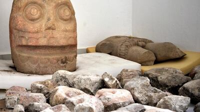 A skull-like stone carving and a stone trunk depicting the Flayed Lord were found at a temple in Puebla, Mexico. INAH via AP