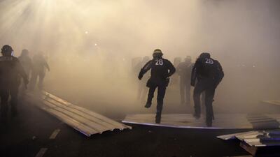 Riot police forces run during clashes with protesters during an anti-government demonstration called by the Yellow Vests "Gilets Jaunes" movement, in Bourges on January 12, 2019. AFP