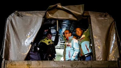 Ambulance personnel and police officers prepare to evacuate a care home after rising floodwaters in South Limburg, the Netherlands.