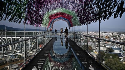 Visitors walk on a skybridge overlooking the border between Thailand's Mae Sai, right, and Myanmar's Tachileik, left, at Wat Phra That Doi Wao Buddhist temple in Mae Sai in the northern Thai province of Chiang Rai. AFP