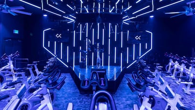 Spin studio Crank is set in a nightclub environment with a DJ spinning party tracks