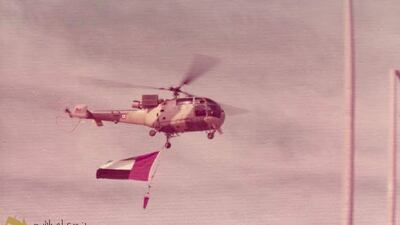 An Alouette III military helicopter flies the flag for UAE National Day celebrations in 1972