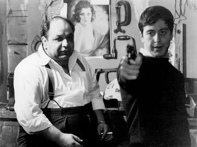 Richard S Castellano watching Al Pacino aim gun in a scene from the film 'The Godfather', 1972. Getty Images