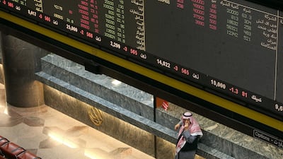 A Kuwaiti trader follows stock prices at the Boursa Kuwait stock market in January. Kuwait's stock market will be upgraded from frontier to emerging market status in May by index provider MSCI. AFP