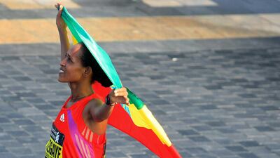 Tirfi Tsegaye Beyene of Ethiopia carries her national flag after she wins the Standard Chartered Dubai Marathon in Dubai, United Arab Emirates, Friday Jan. 25, 2013. (AP Photo) *** Local Caption *** Mideast Emirates Dubai Marathon.JPEG-0da46.jpg