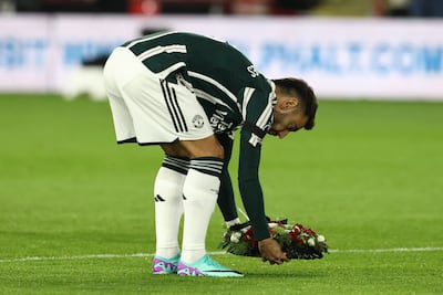 Manchester United's captain, Portuguese midfielder Bruno Fernandes, lays a floral wreath for legendary United and England midfielder Sir Bobby Charlton whose death was announced before kick-off. AFP