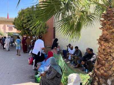Volunteers distribute water and food to families of earthquake survivors at King Mohamed VI University Hospital. The National