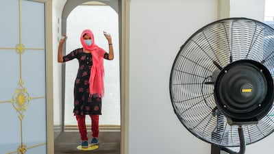 Churchgoers walk through a sanitation tunnel and pass a thermal scanner before entering St Joseph's. Victor Besa / The National