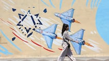 An Iranian girl walks past an anti-Israeli mural on a street in Tehran. EPA