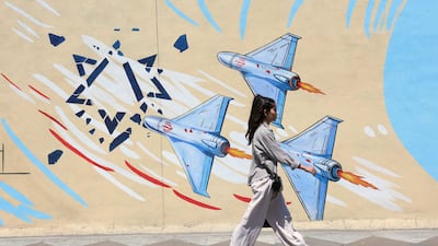 An Iranian girl walks past an anti-Israeli mural on a street in Tehran. EPA