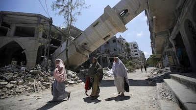 Palestinians walk under the minaret of a destroyed mosque in Gaza. Israel not only are profiting from the reconstruction but also turning the territory into a super-maximum prison. Photo: Mohammed Saber / EPA