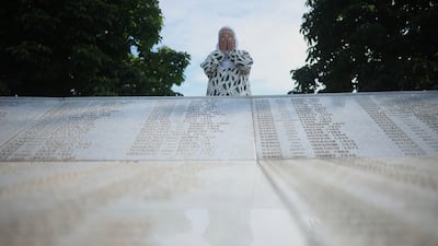 A Bosnian Muslim woman mourns next to a monument with the names of the victims of Srebrenica genocide, at the Memorial Centre in Potocari, Bosnia. AP