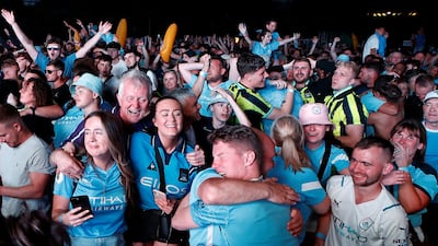Manchester City fans celebrate winning the Champions League at Manchester's 4TheFans Fan Park. Reuters