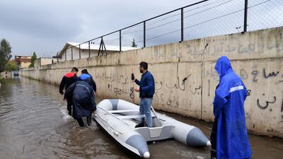 Iraqis prepare a dinghy boat to use a a means of transportation in a street flooded by heavy rain in the northern Iraqi city of Mosul. AFP