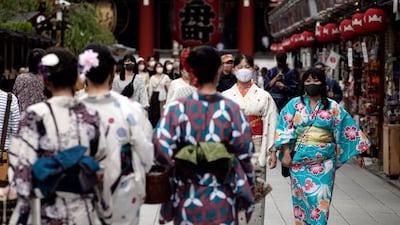 People wearing protective masks to help curb the spread of the coronavirus walk at a shopping arcade at Asakusa district, Tokyo. The Japanese capital confirmed more than 200 coronavirus cases on Tuesday. AP Photo