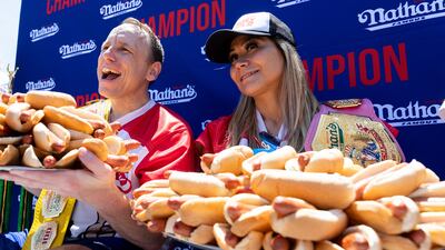 Mr Chestnut and women's champ Miki Sudo pose with 63 and 40 hot dogs, respectively, after winning the Nathan's Famous Fourth of July hot dog eating contest. AP