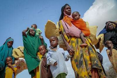 Somalis who fled drought-stricken areas carry their belongings as they arrive at a makeshift camp for the displaced near Mogadishu. AP
