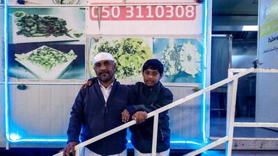 Mohammed Abdulla stands with his son, Salem, 13, outside the family's Yemeni restaurant at the Al Dhafra Festival. Victor Besa / The National