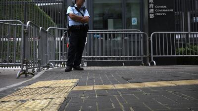A policeman stands on pavement reinforced with glue to prevent the bricks from being dug up and used as projectiles during expected protests outside the central government offices in downtown Hong Kong. Isaac Lawrence / AFP Photo