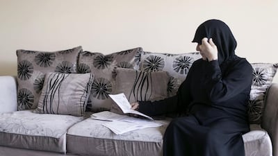 Dalal Alali, 53, looks through her costly medical records. At the hospital where the Syrian expatriate is being treated for bone and breast cancer, doctors say the cost of her chemotherapy will run into tens of thousands of dirhams. Reem Mohammed / The National