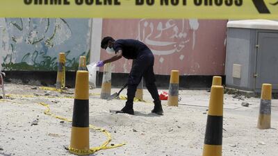 An explosives specialist police officer collects samples after a bomb blast in the village of Sitra, south of Manama, Bahrain, July 28, 2015. Hamad I Mohammed / Reuters